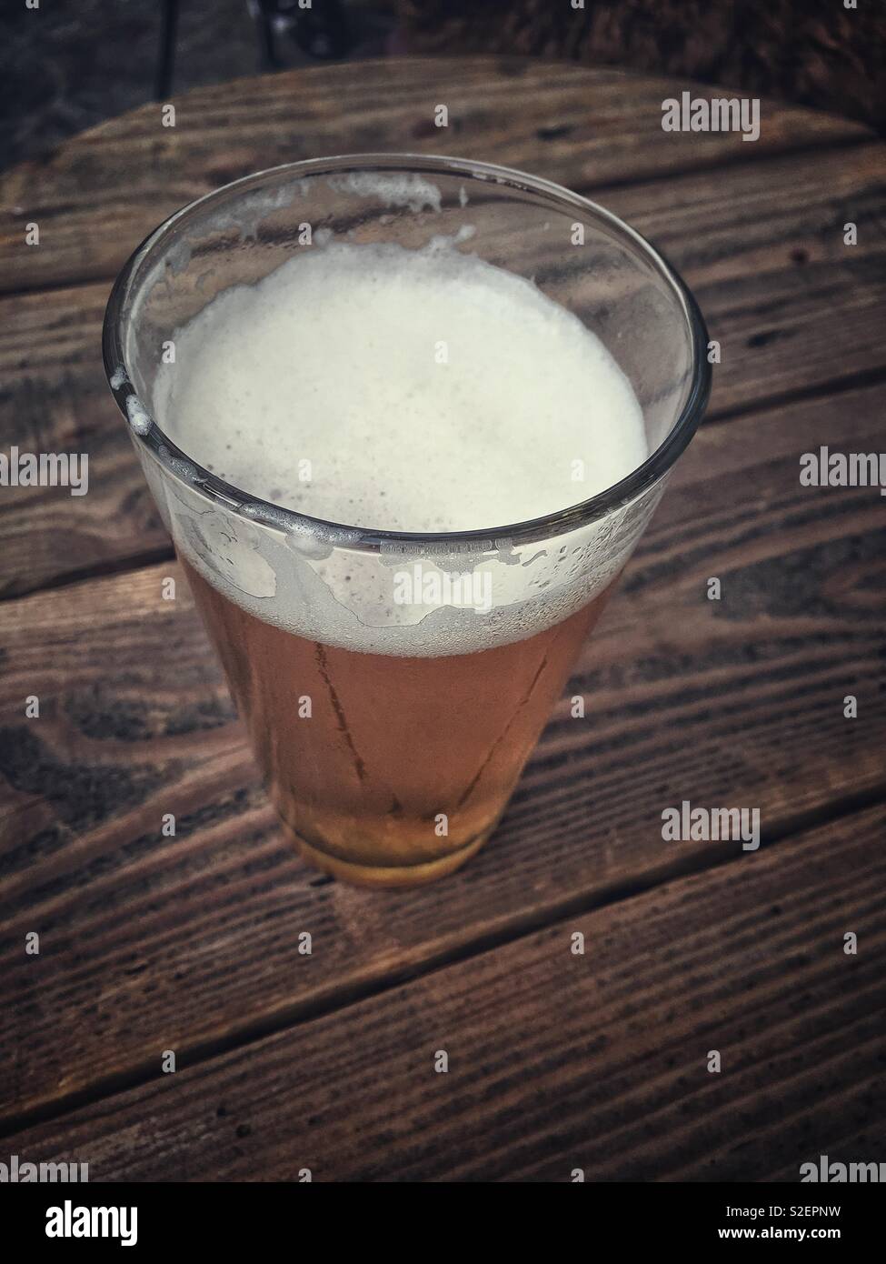 Ein Glas Bier auf einer hölzernen Tisch Stockfoto