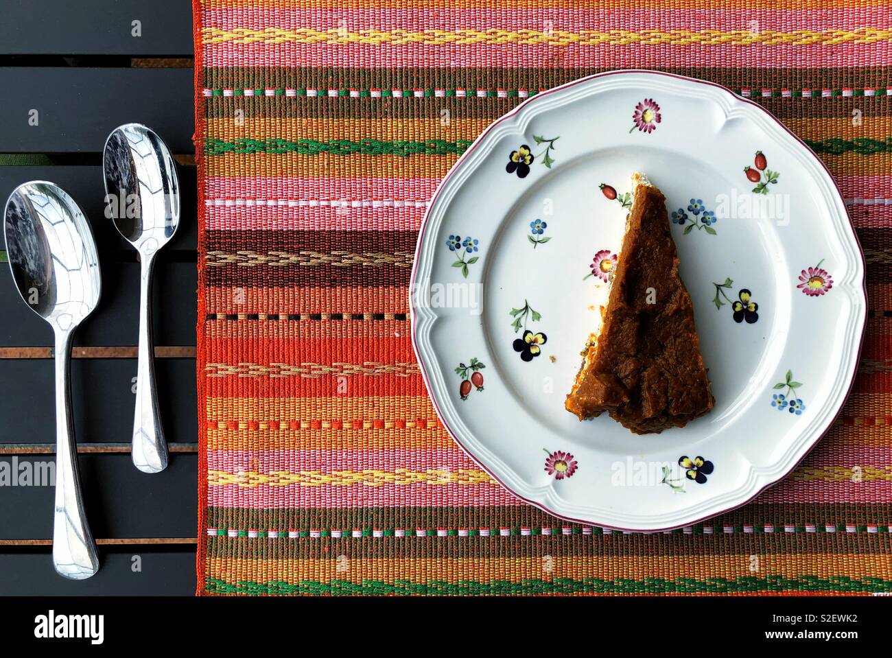 Vegan pumpkin Cheesecake auf nette Platte und Stripy gewebte Tischset für Thanksgiving Abendessen - Smartphone-aufgenommenes Stockfoto