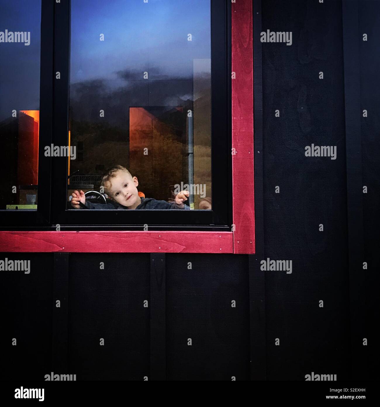 Kleiner Junge durch das Fenster gesehen Stockfoto