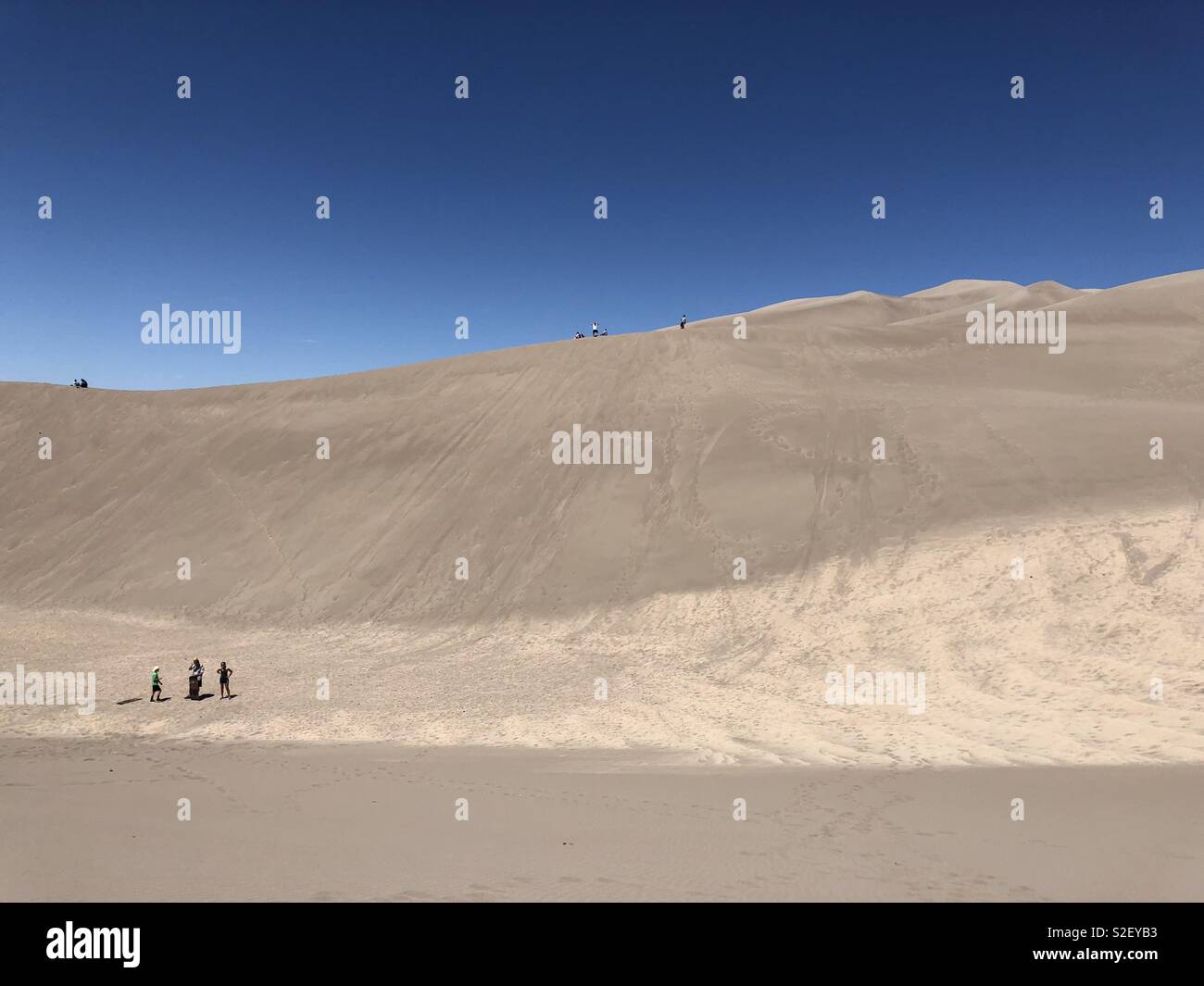 Besucher Great Sand Dunes National Park in Colorado Wanderung durch den größten Sanddünen in den Vereinigten Staaten. Besucher können Schlitten mieten, Sand und sand Boards die Dünen hinunter bis zu 35 mph zu schieben. Stockfoto