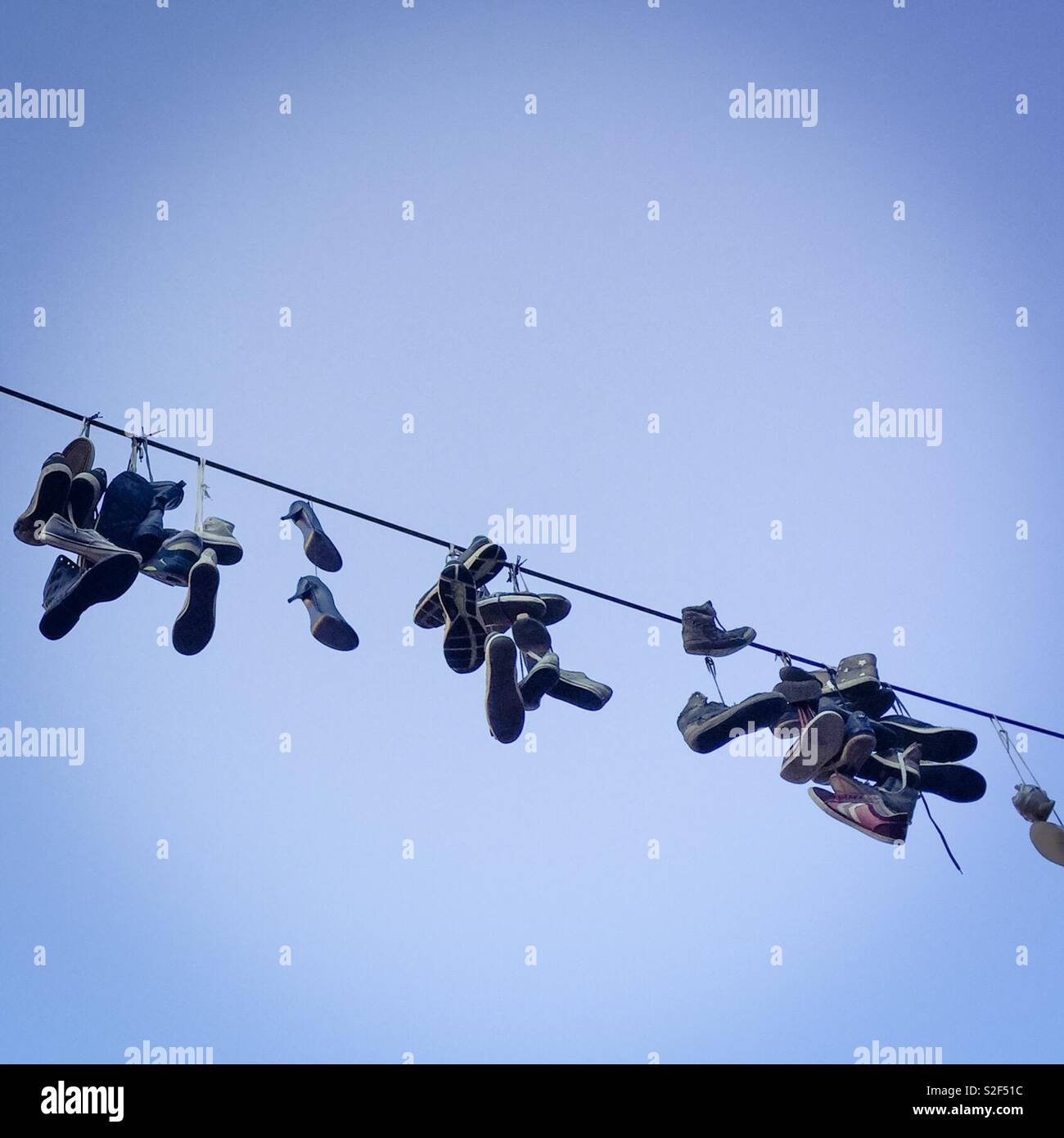Schuhe hängen von einem Draht Stockfoto