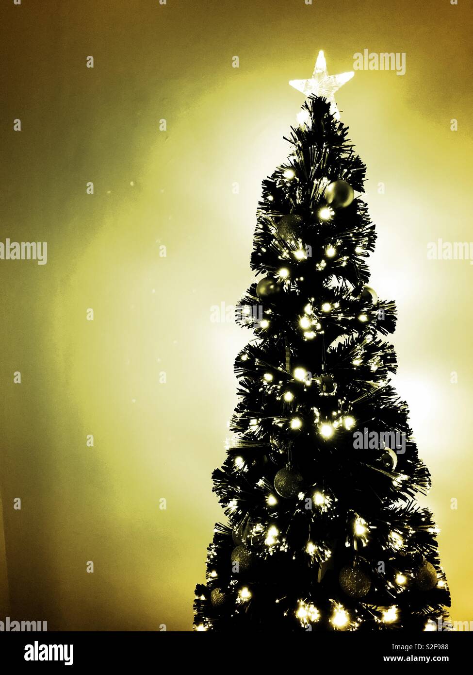 Glühende schwarze Weihnachtsbaum mit silbernen Verzierungen und goldenen Glanz Stockfoto