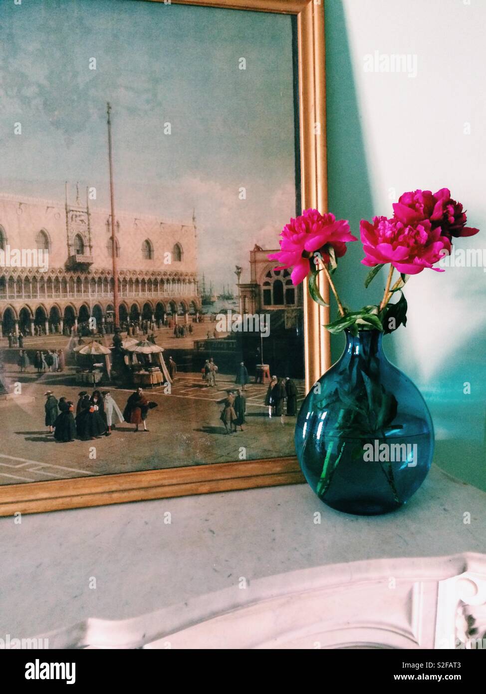 Vase mit Blumen und antiken Drucken von Venedig auf Marmor Mantel Stockfoto