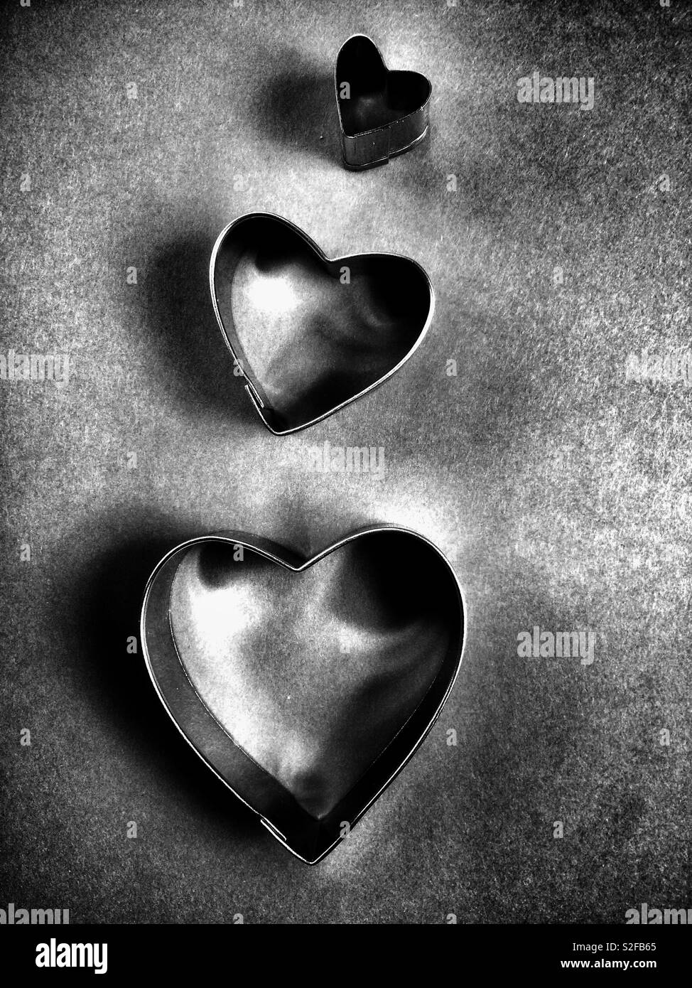 Eingestellt von metallischen Herzen verschiedener Größen in monochromen Ton Stockfoto