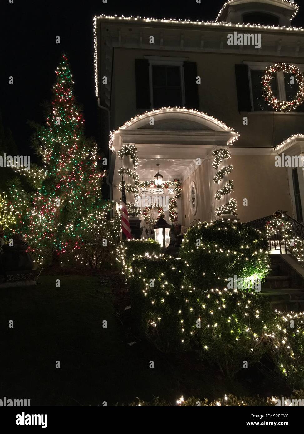 Weihnachten Dekorationen und Lichter auf ein großes Haus und Baum - Smartphone-aufgenommenes Stockfoto