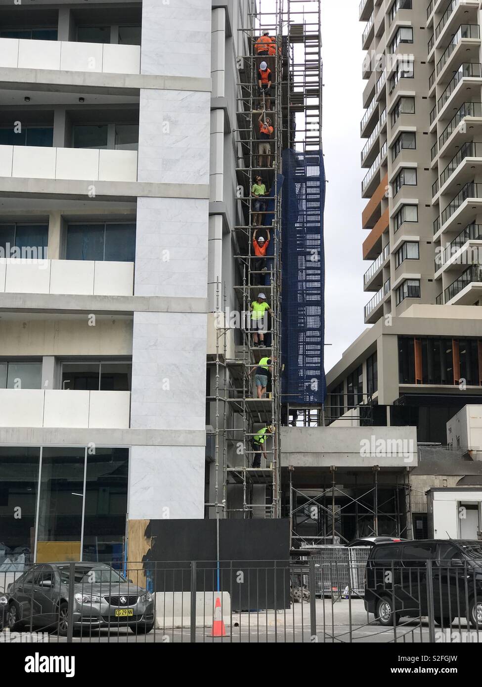 Handwerker übereinander auf Gerüsten auf einer Baustelle in Redfern, Sydney, Australien Stockfoto