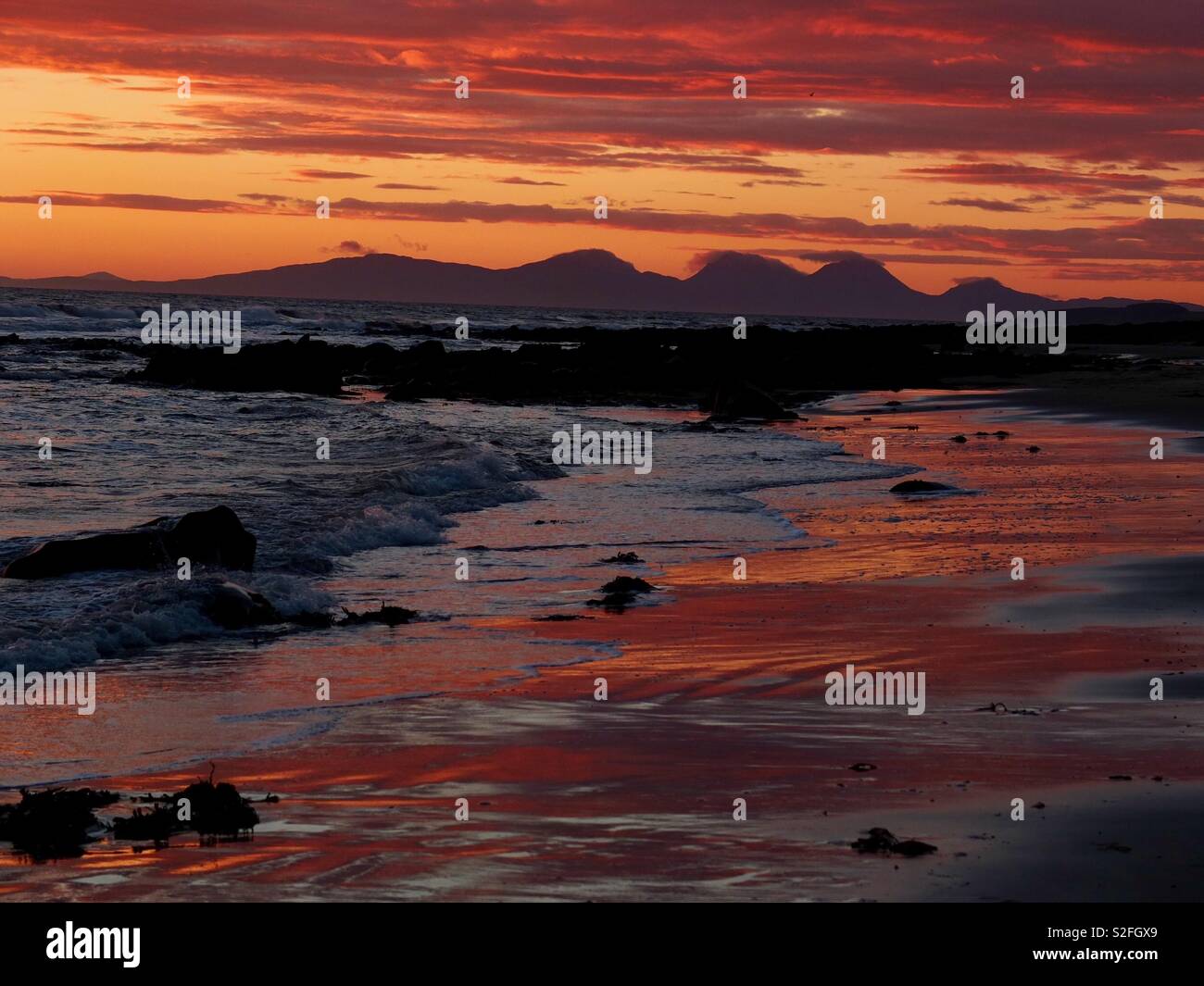 Kintyre Seascape mit Blick in Richtung Isle of Jura bei Sonnenuntergang von glenbarr Strand Stockfoto