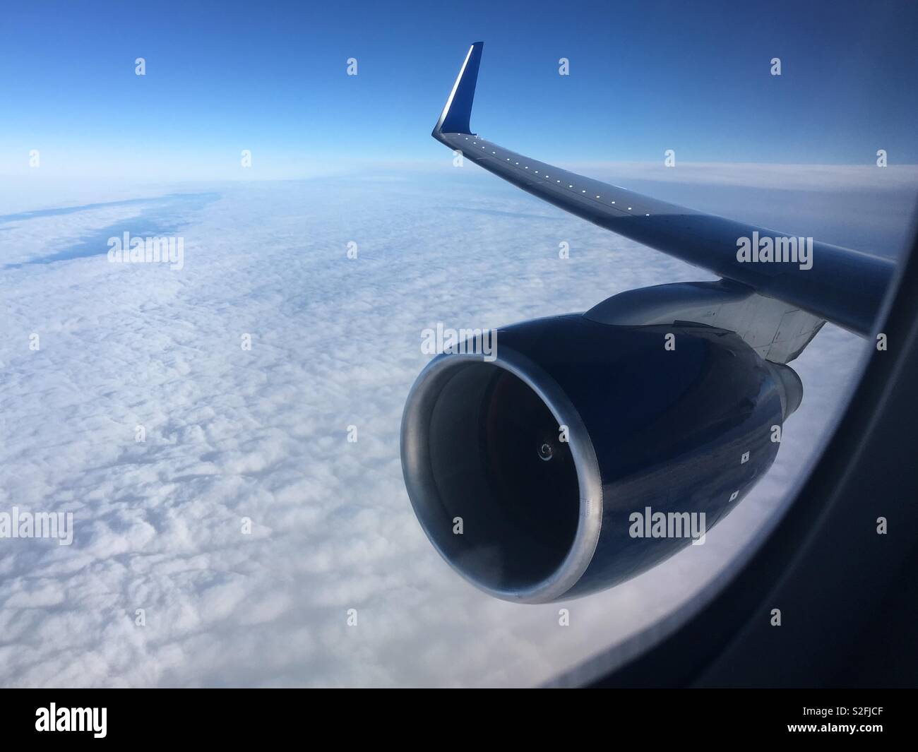 Turbofan Jet Motor und Flügel durch Flugzeuge Fenster beim Flug über den Wolken gesehen Stockfoto