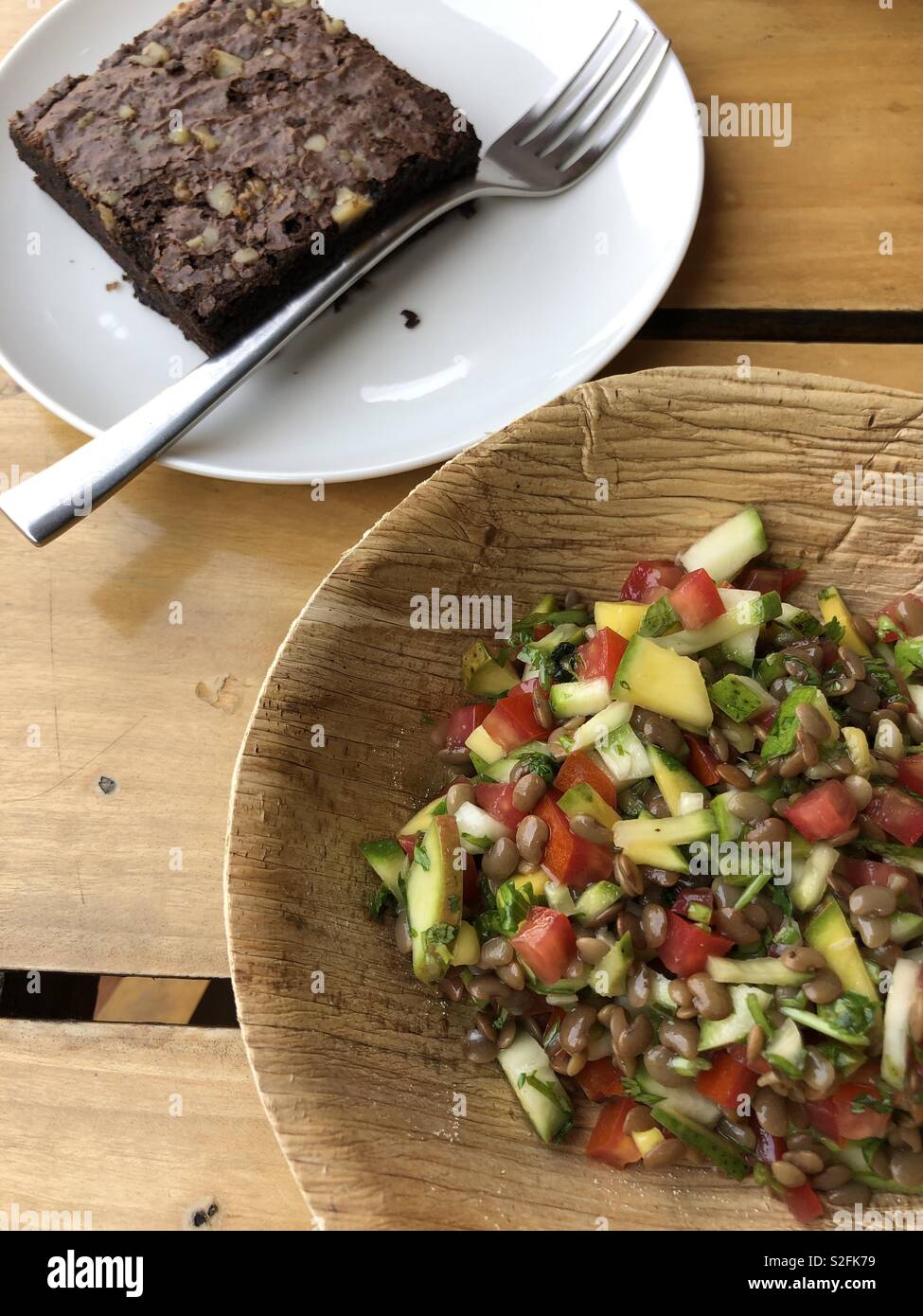 Organische, kein Abfall: frische Mango Salat in einer Kompostierbaren Schüssel und einen leckeren Schokoladenkuchen neben Stockfoto