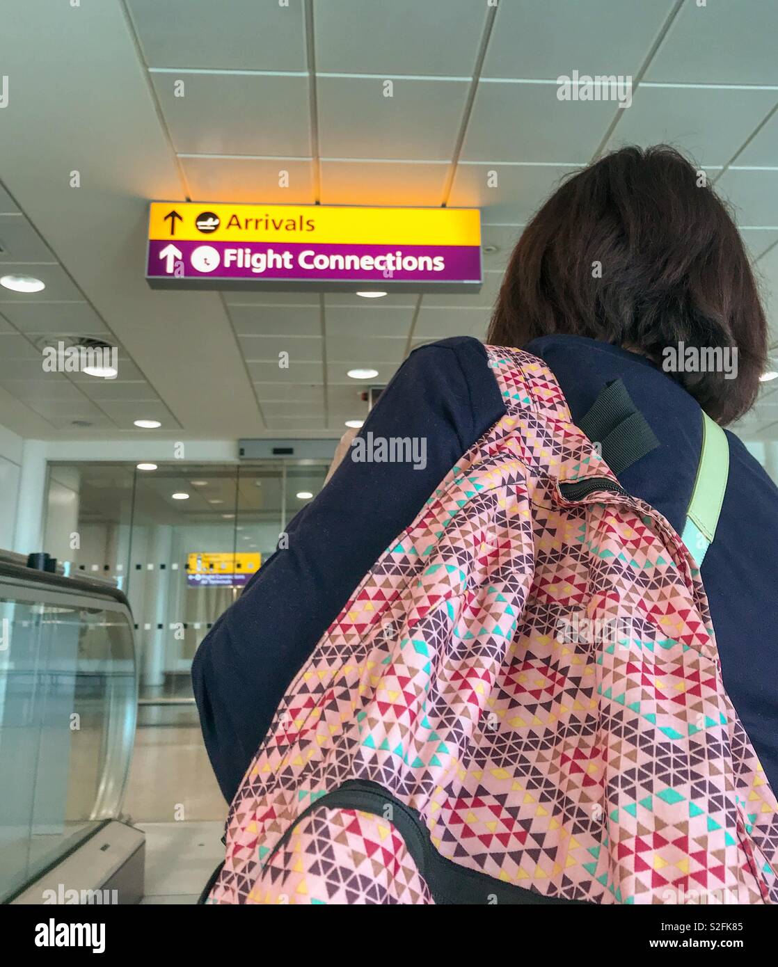 Person mit Rucksack in einem Flughafen Terminal nach Ihr Flugzeug Stockfoto