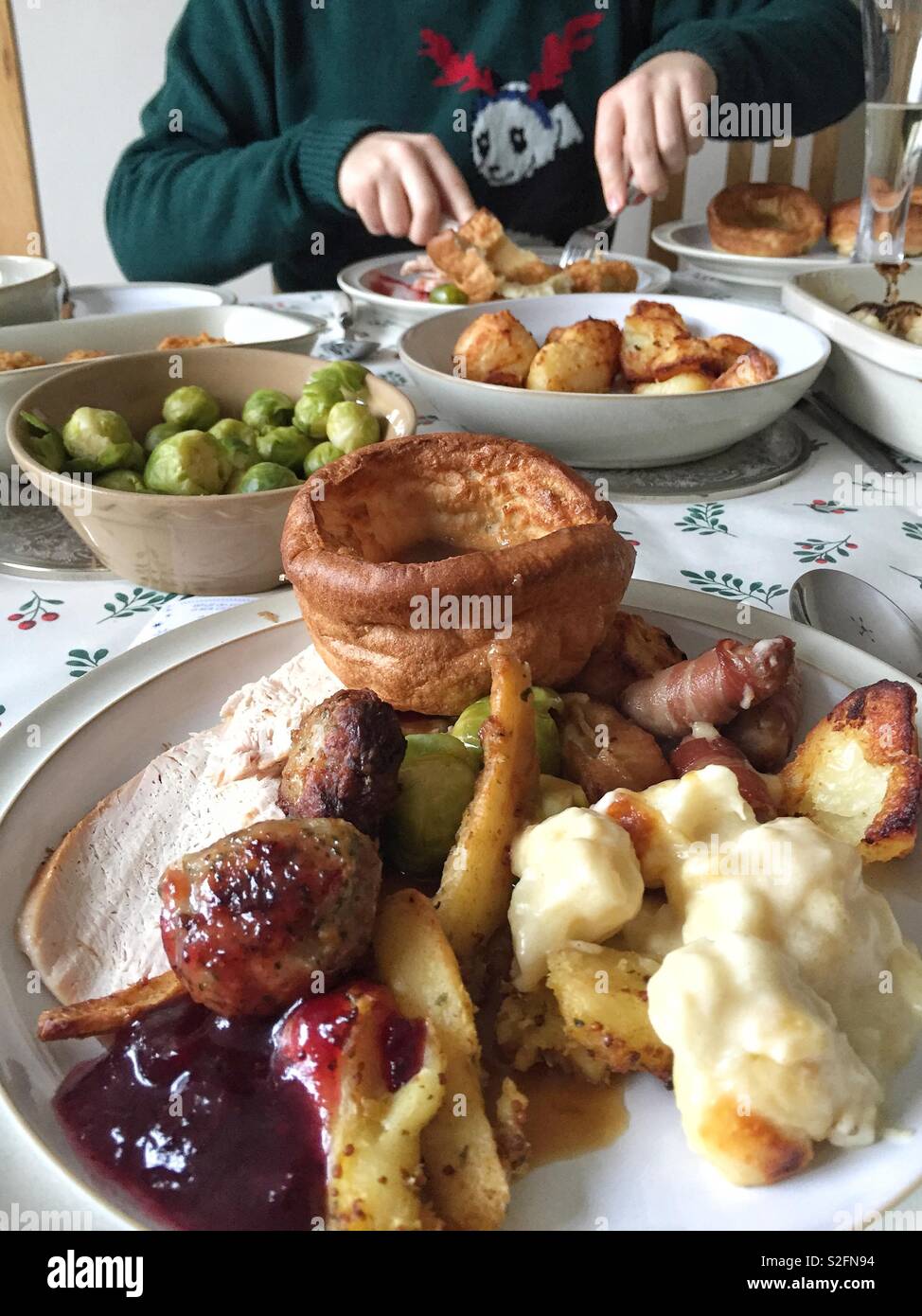 Ein Weihnachtsessen Tabelle mit Platten voller festliche Essen einschließlich Sprößlinge der Türkei und Yorkshire Pudding. - Smartphone-aufgenommenes Stockfoto