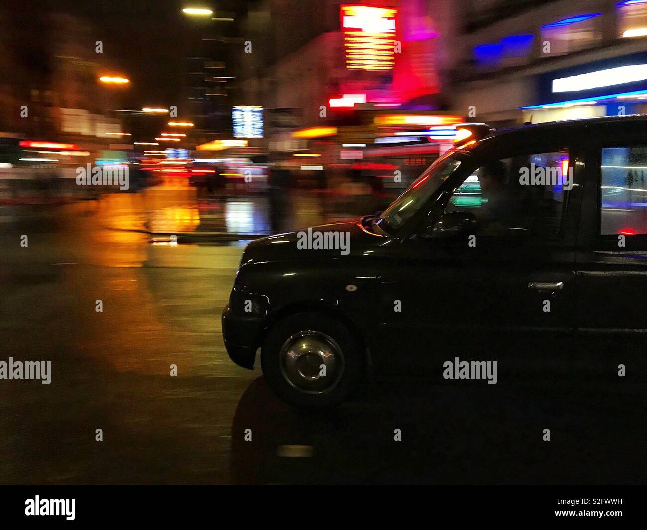 London Taxi mit Motion verschwommen Lichter der Stadt im Hintergrund Stockfoto