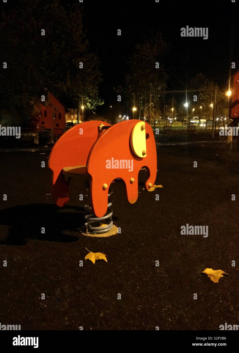 Holz- Elefant in einen Kinderspielplatz in der Nacht mit ferne Lichter Stockfoto
