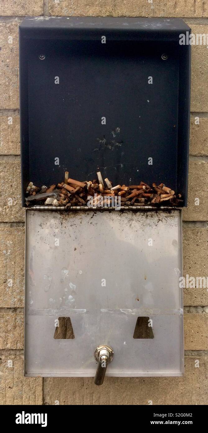 Dirty Zigarettenstummel in offenen Dispenser - Smartphone-aufgenommenes Stockfoto