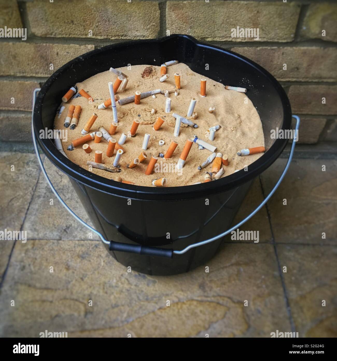 Eimer Sand und Zigarettenkippen - Smartphone-aufgenommenes Stockfoto