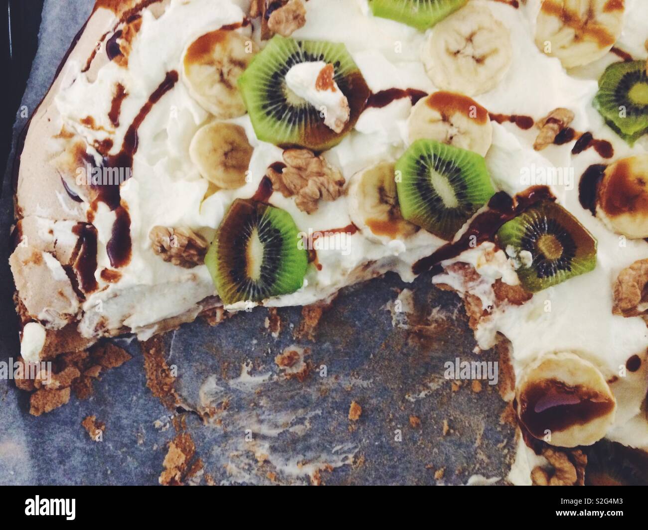 Dessert: Eine Pavlova mit Kiwi und Banane Schichten Stockfoto