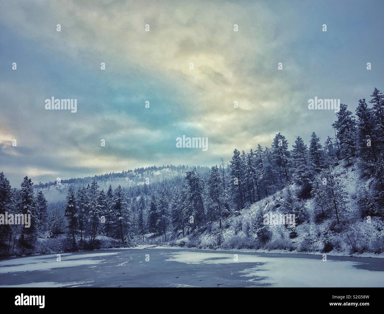 Winterlandschaft mit gefrorenen See, Berge und Schnee bedeckte Bäume. Stockfoto