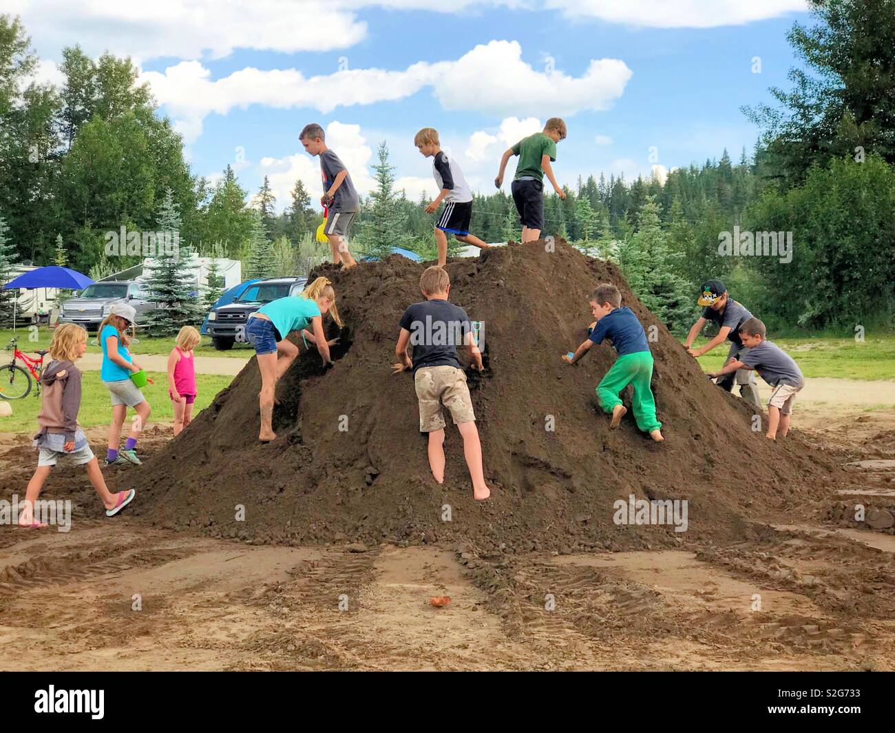 Viele Kinder graben sie in einem frischen großen Haufen von Schmutz. Stockfoto