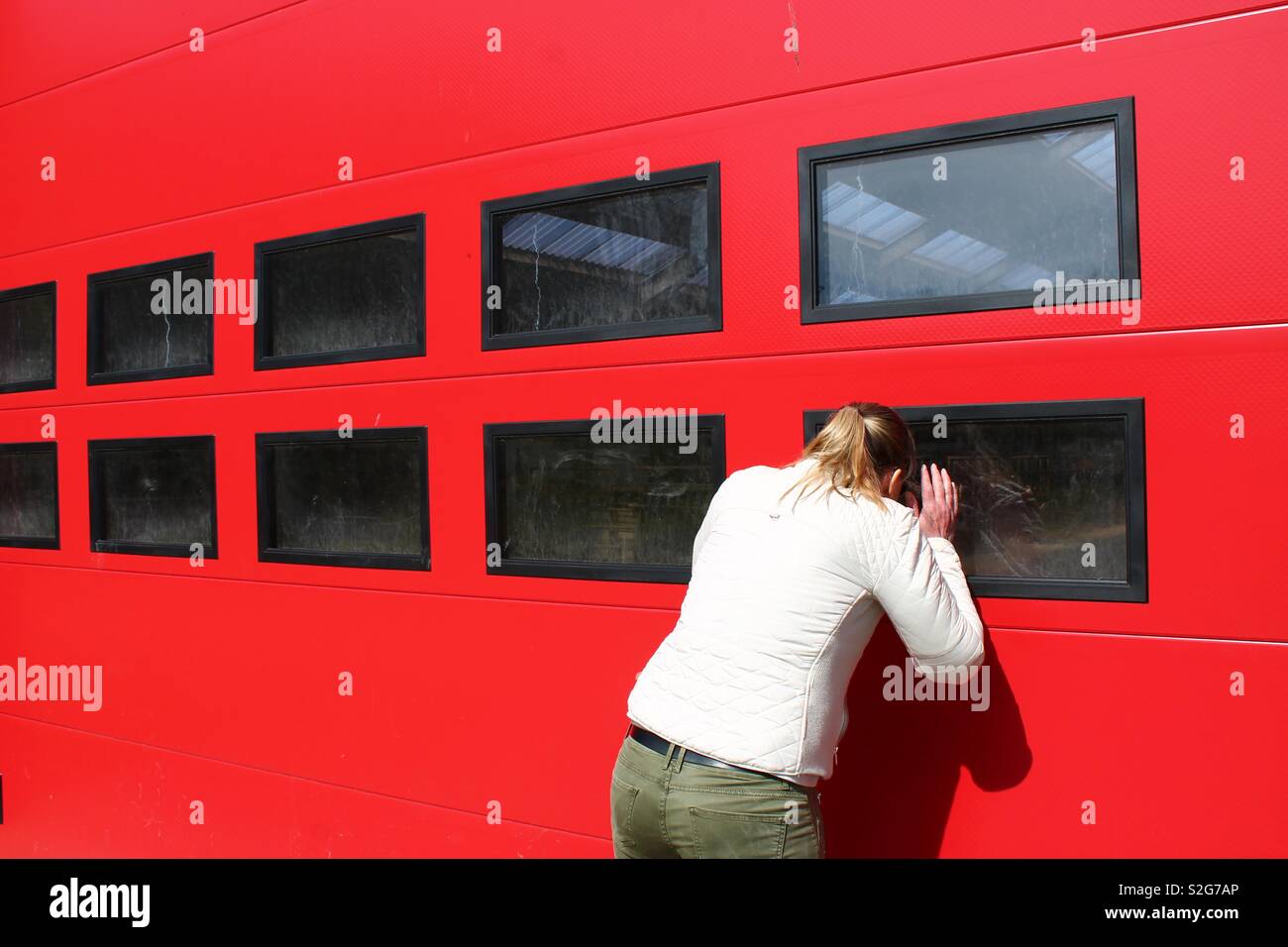 Frau spähen durch ein Fenster Stockfoto