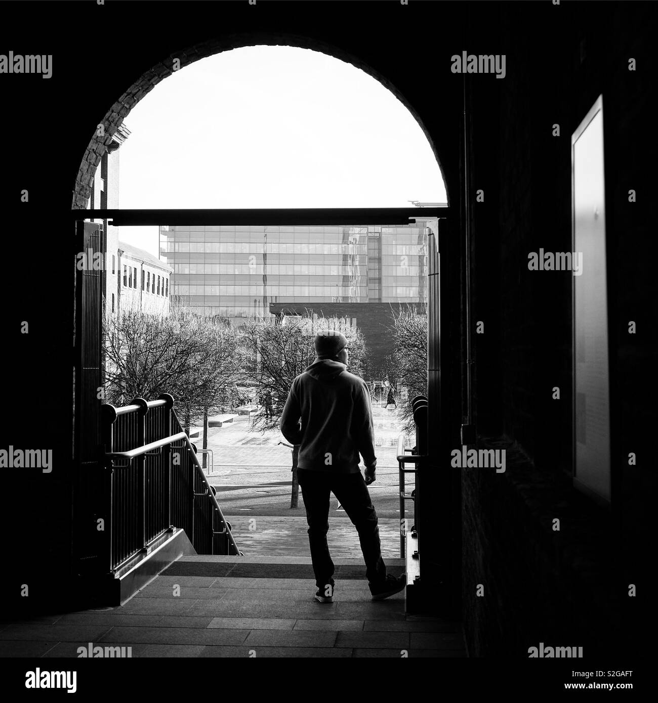 Ein einsamer Mann über Getreidespeicher Square, London Kings Cross, Großbritannien suchen Stockfoto