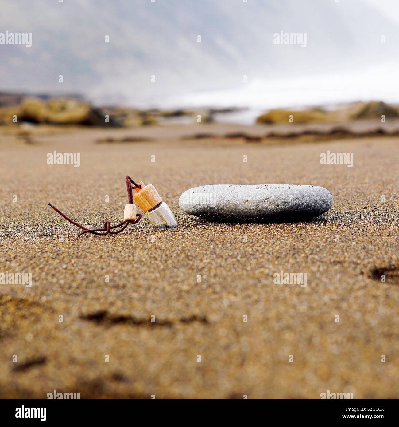 Flasche und Rock im Strand Stockfoto