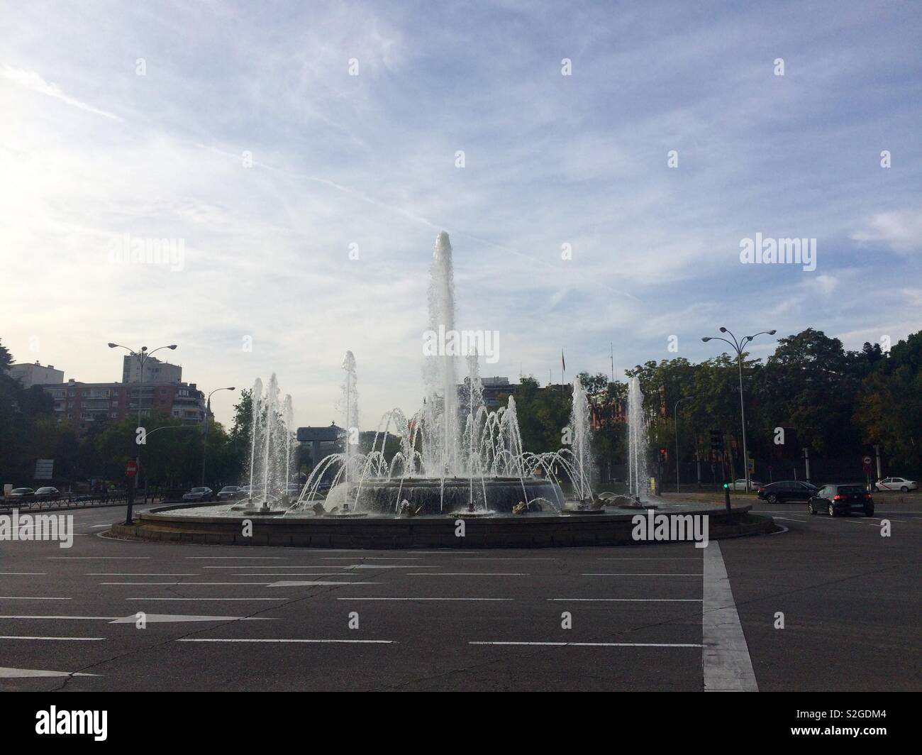 Kreisförmigen Springbrunnen in der Mitte der breiten Straße in der Stadt Madrid Spanien - Smartphone-aufgenommenes Stockfoto