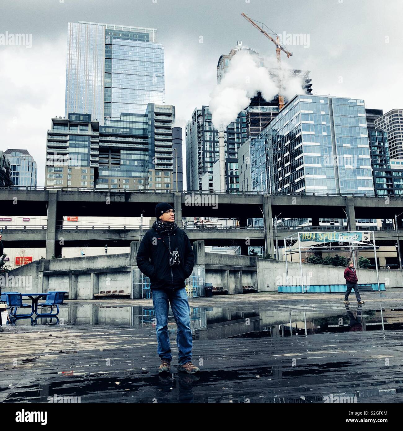 Mann mit Kamera vor der alaskischen Viadukt in Seattle Waterfront posing Stockfoto