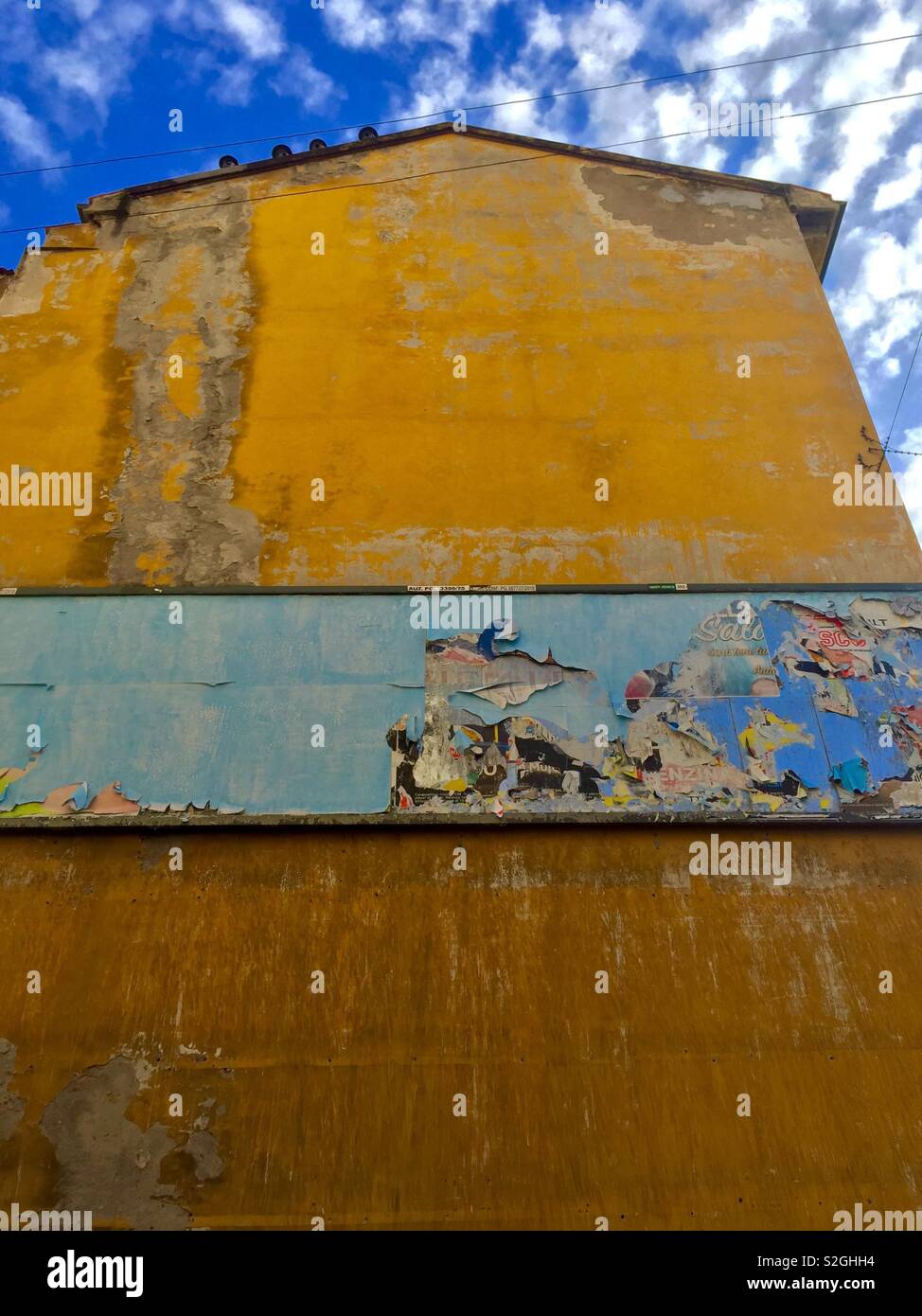 Gebäudewand mit Werbung Poster sky Fassade fallen Dekadenz decay chromatische Kontrast Qual Stockfoto
