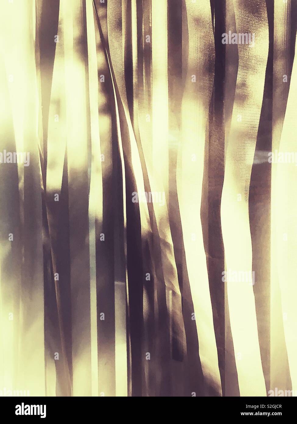 Abstrakte goldenen Licht Muster durch die Gaze und Jalousien Stockfoto