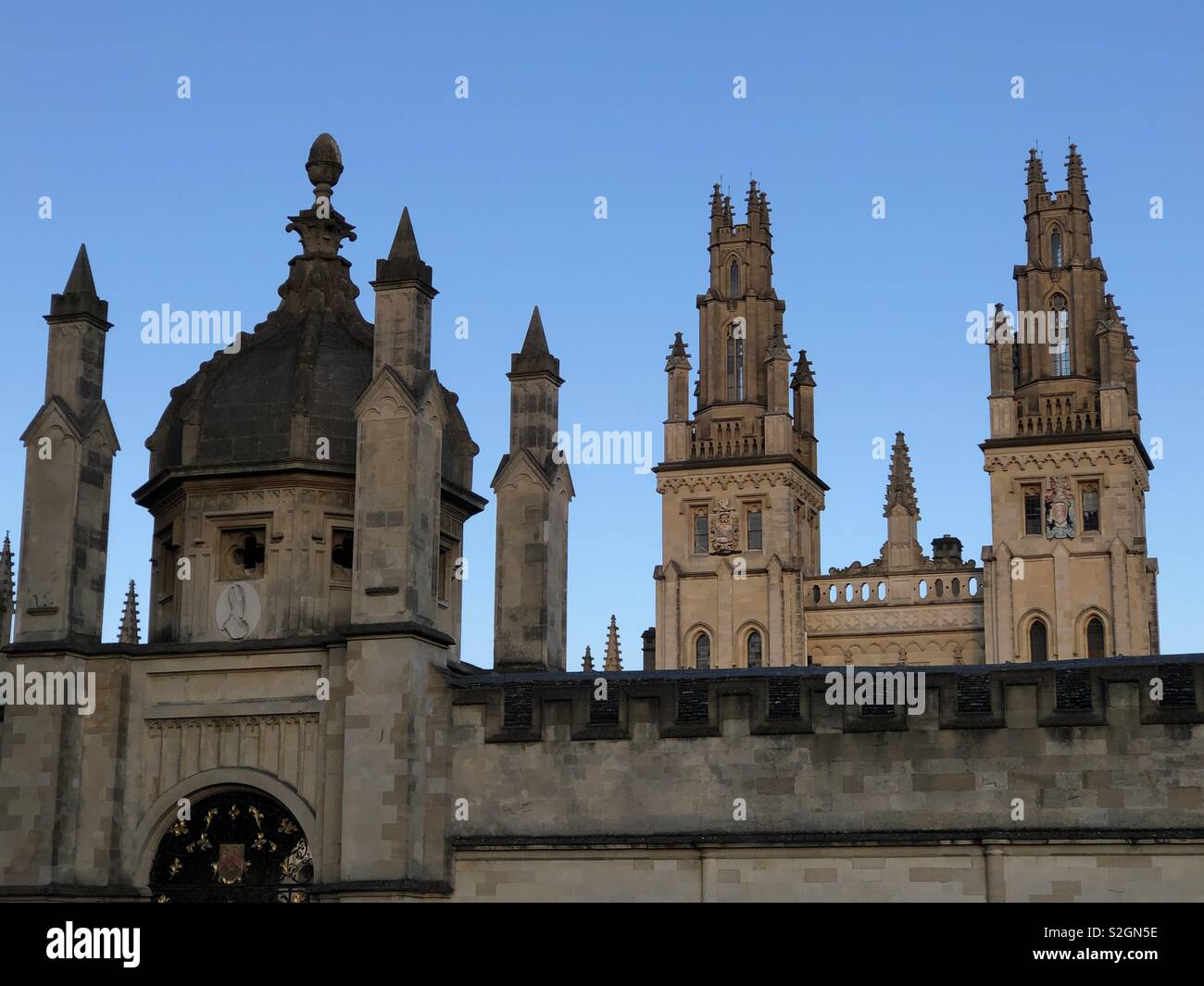 Blick auf einige der "Dreaming Spires' in Oxford, am All Souls College, Oxford University; eine stimmungsvolle Aussicht bei Sonnenuntergang, einschließlich der berühmten Twin Towers von Nicholas Hawksmoor. - Smartphone-aufgenommenes Stockfoto