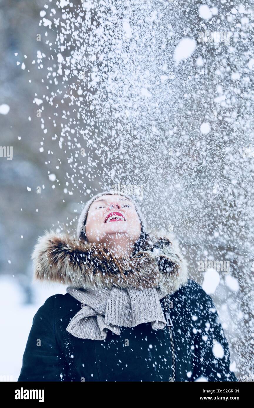 Glücklich lächelnde Frau mit wenig Schnee. Winter. Stockfoto
