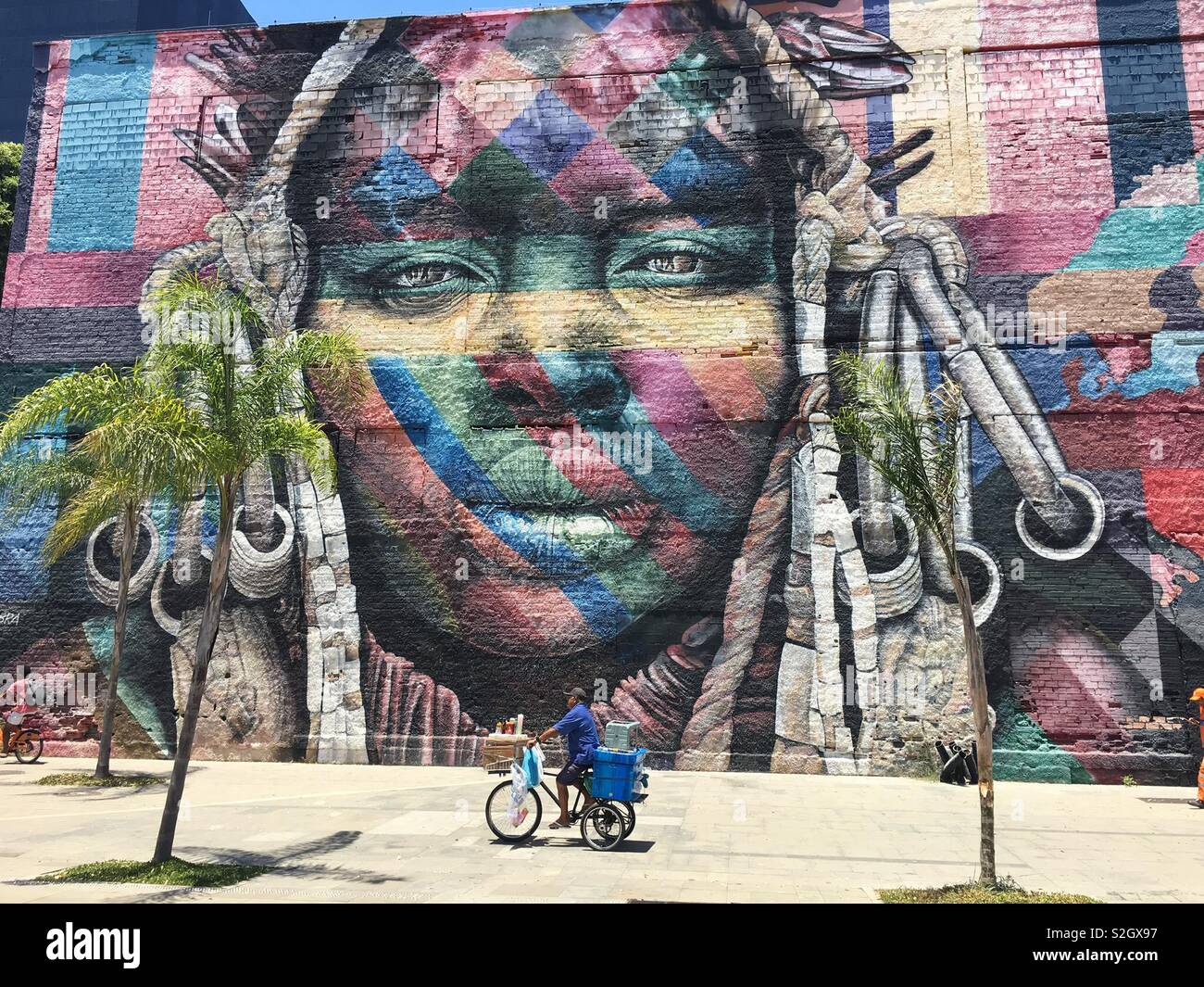 Ein brasilianischer Radfahrer vor einer afrikanischen Frau auf Olimpico Boulevard in Rio Stockfoto