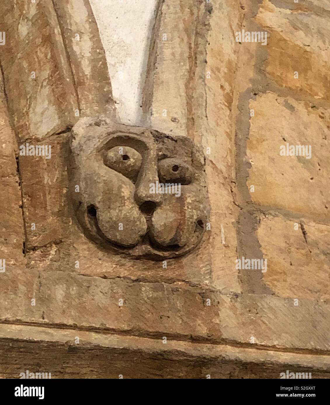 Mittelalterliche humorvoll Skulptur eines googly-eyed cat aus dem 13. Jahrhundert in einer Kirche in Oxfordshire. - Smartphone-aufgenommenes Stockfoto
