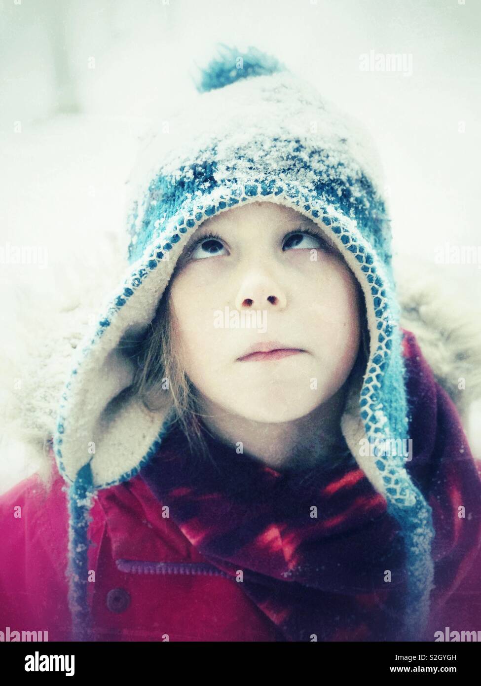 Dumme Portrait von 6 jährigen Mädchen Kreuzung Augen bei Schnee auf dem Kopf suchen Stockfoto