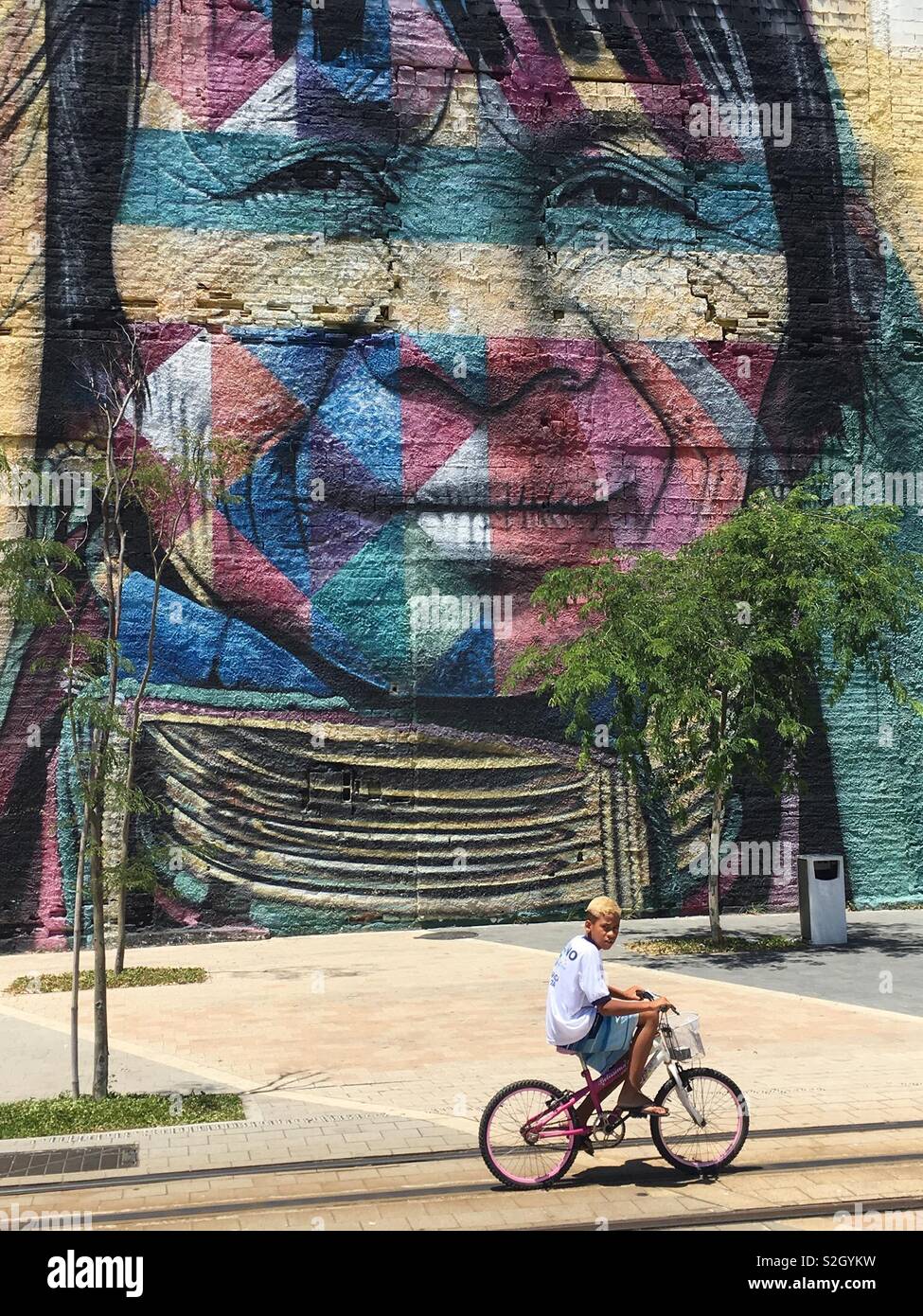 Junge Biker am Boulevard Olimpico in Rio mit schönen Gemälde an der Wand Stockfoto
