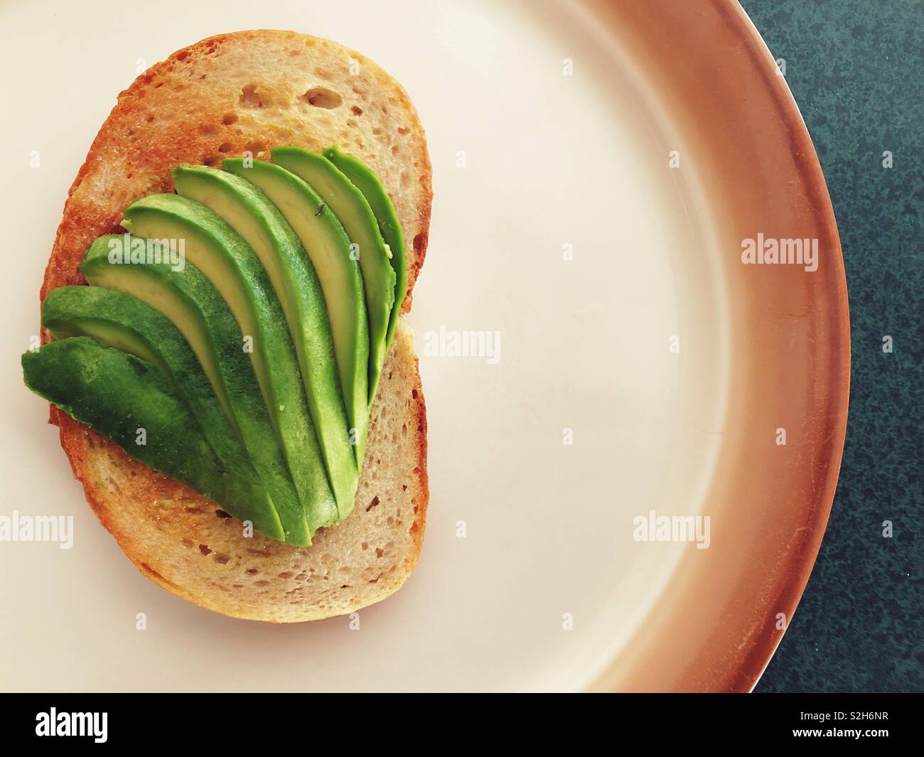 Avocado in Scheiben geschnitten auf Toast auf einer Platte Stockfoto