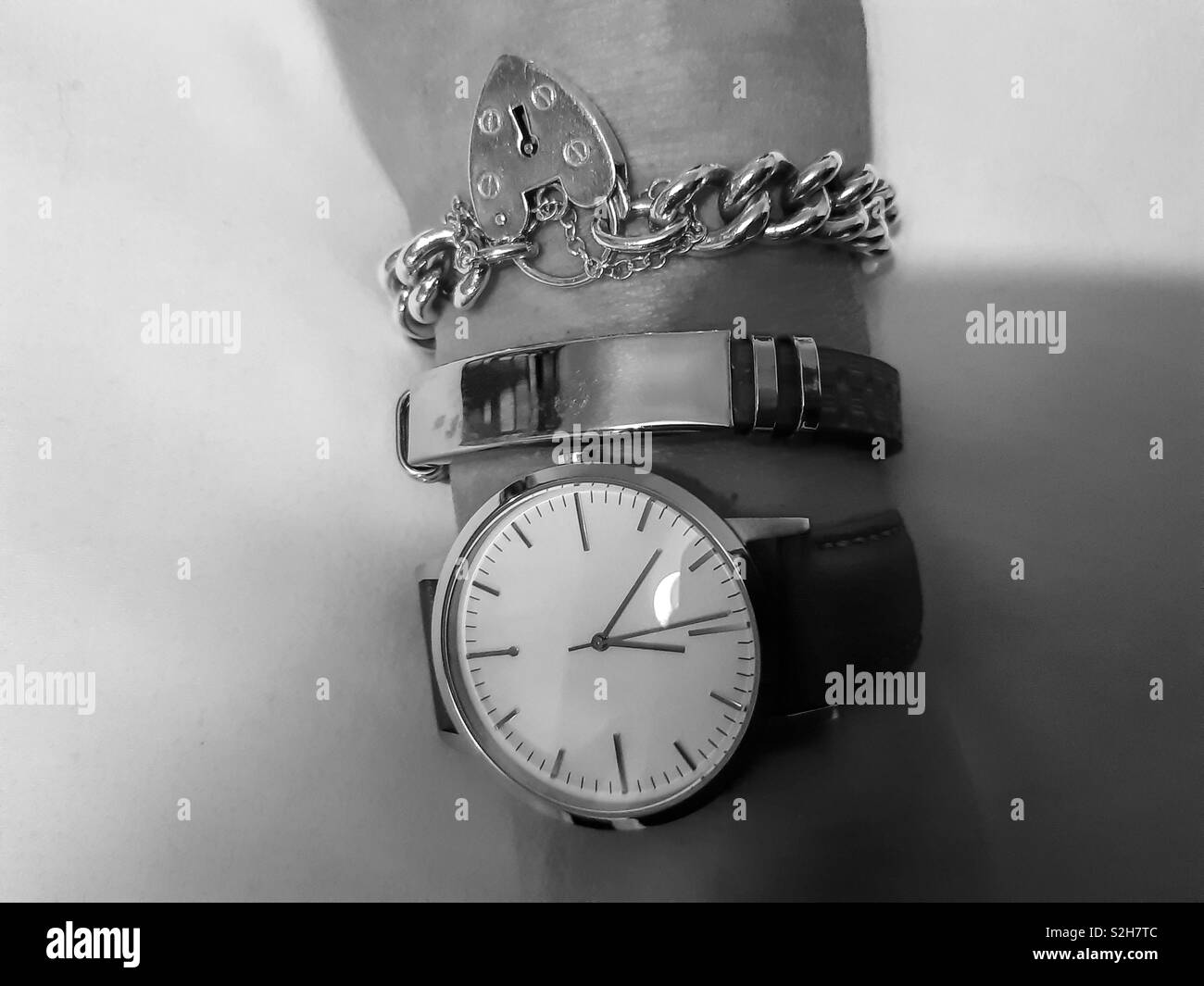Uhr mit Gurt und einer Tan Tan Leder Armband mit einem Silver Charm Armband Stockfoto