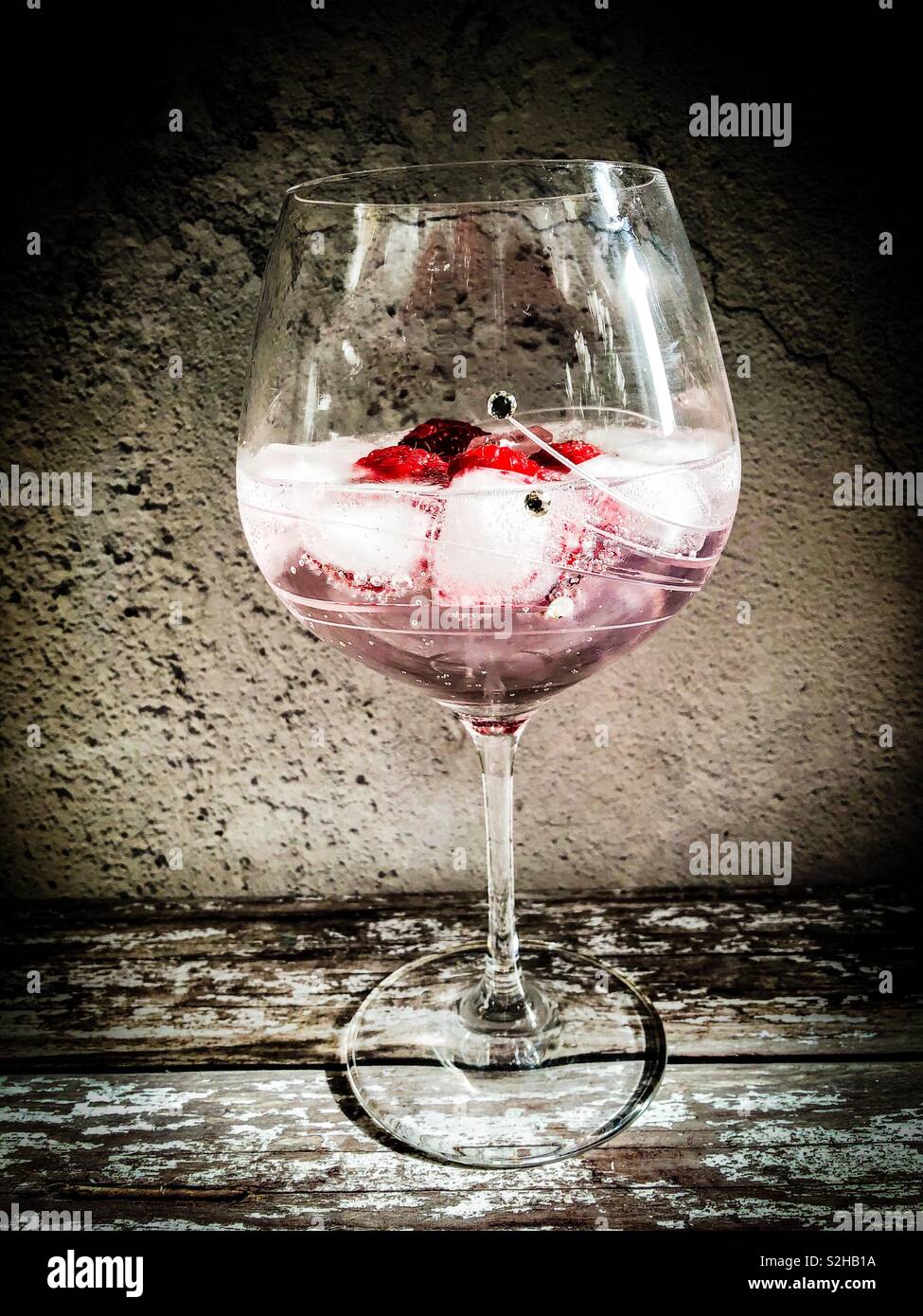 Pink Gin Tonic mit Eis. Mit Himbeeren garniert Stockfoto