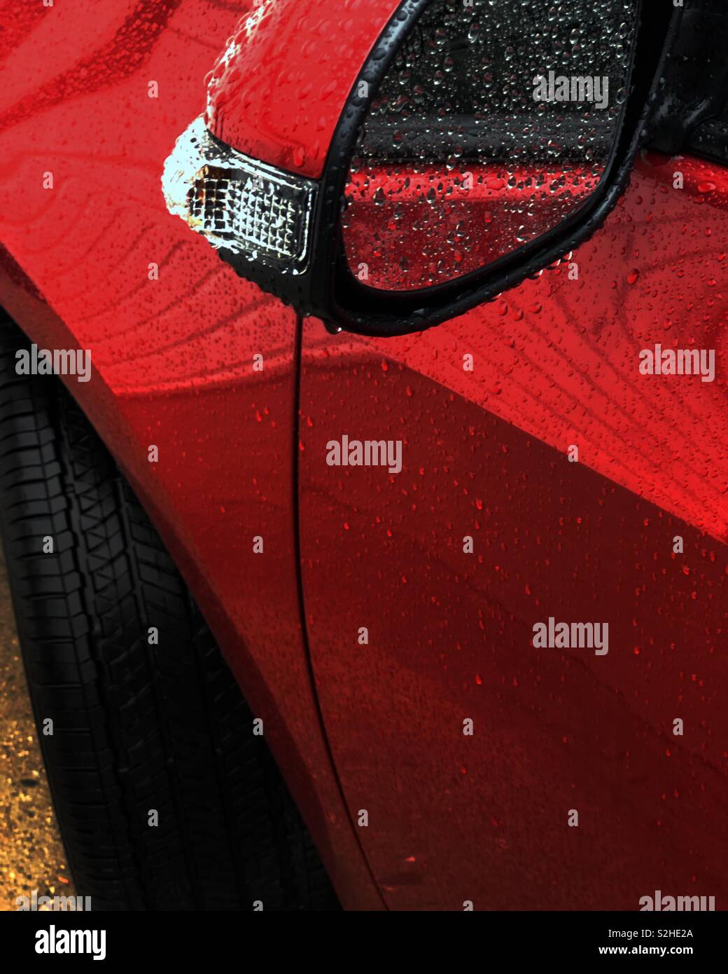 An einem regnerischen Nachmittag in Los Angeles, spiegelt sich in den Spiegel von einem geparkten Auto. Die minimale Zusammensetzung verengt den Fokus auf den nassen Texturen aus Metall und Glas. Stockfoto