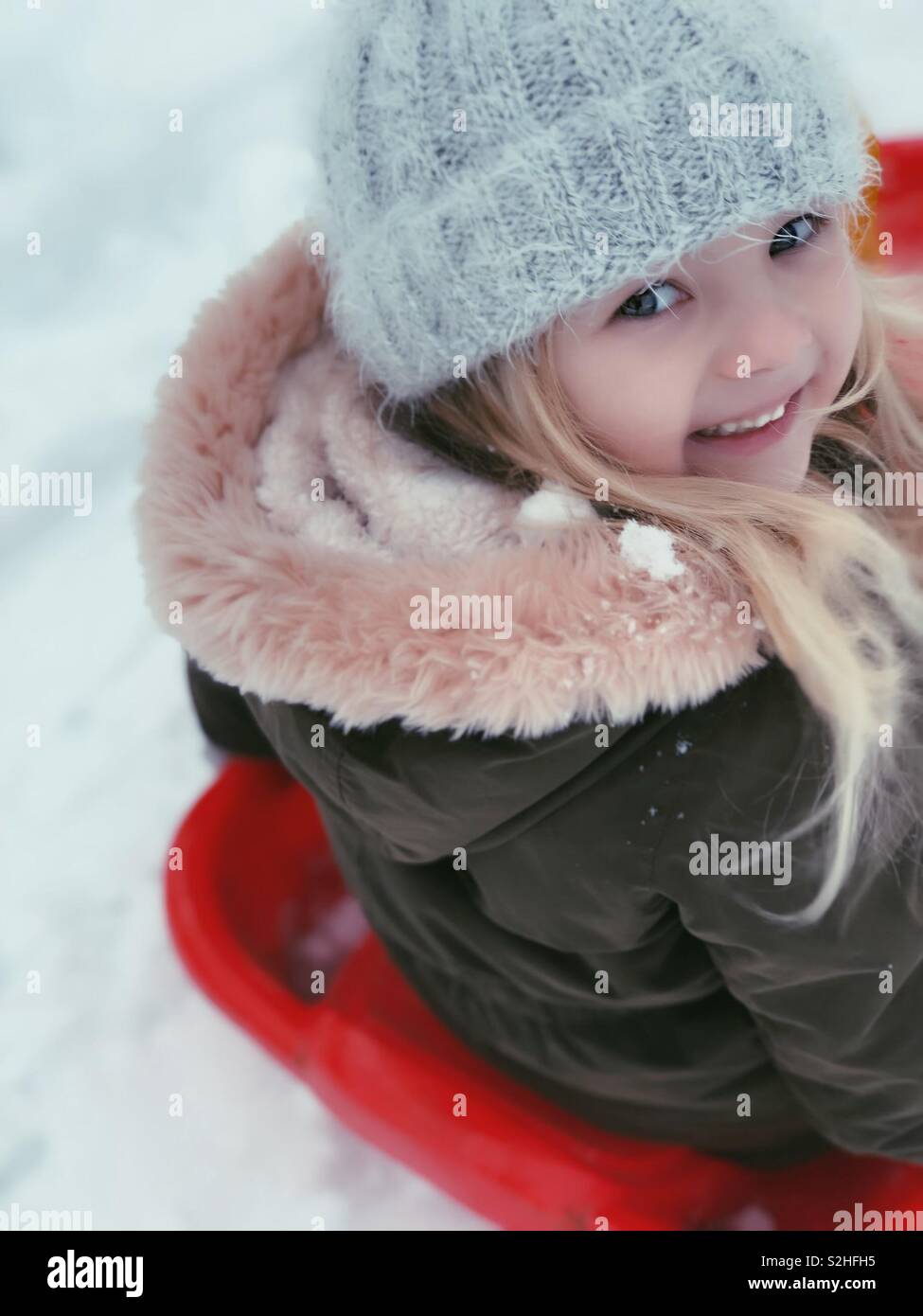 Kleines Mädchen lächelnd im Schnee Stockfoto