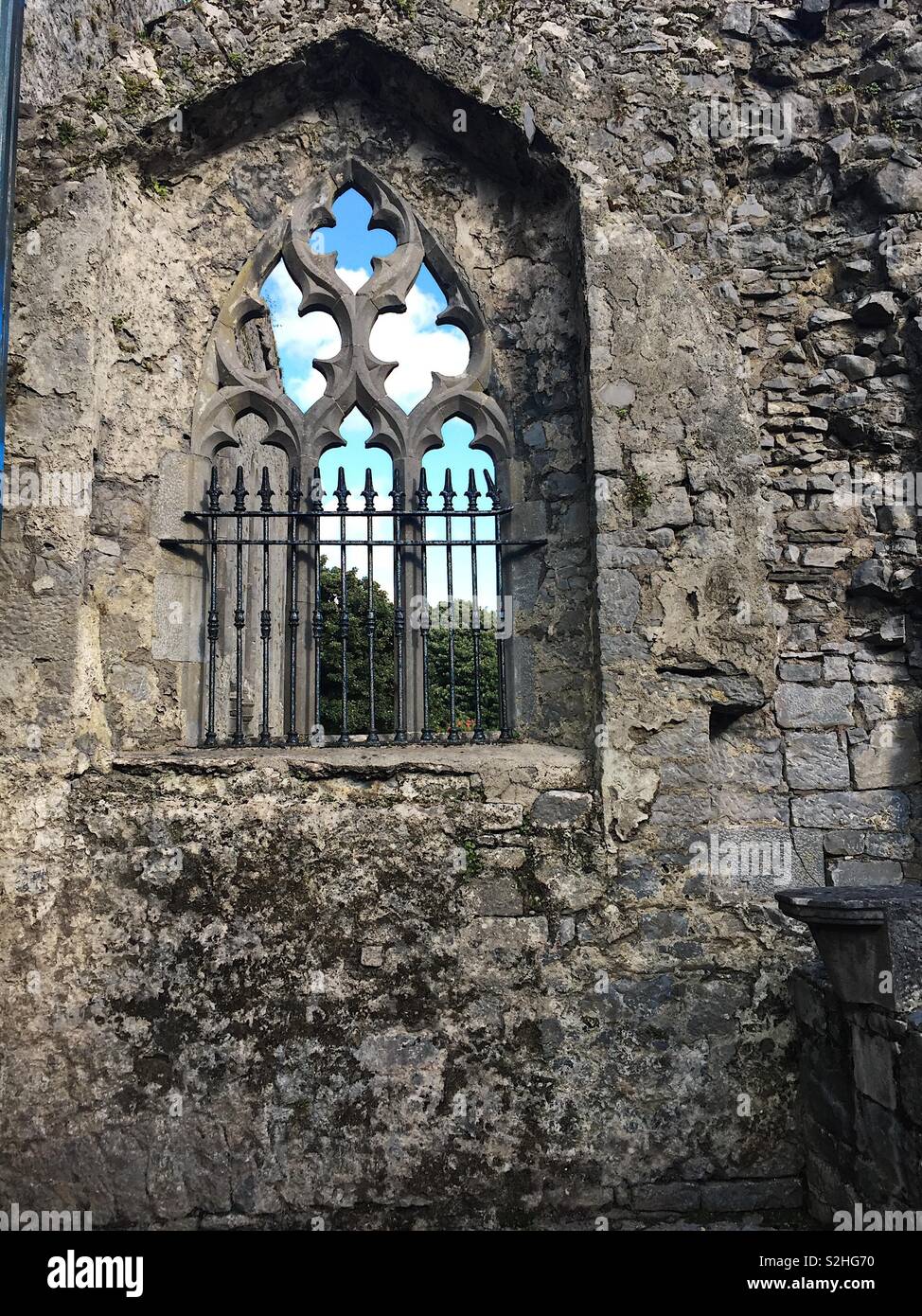 Mittelalterliche Rundbogenfenster an Ennis Kloster in Irland auf der Suche nach Gelände Stockfoto