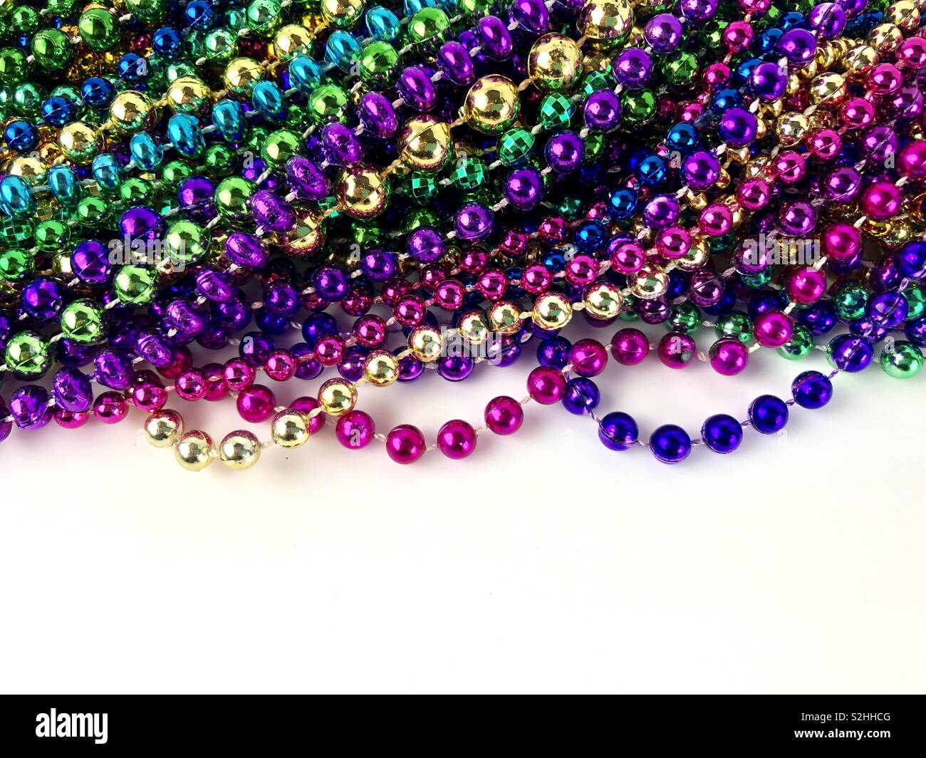 Mardi Gras Perlen auf einen weißen Hintergrund mit Kopie Raum - Smartphone-aufgenommenes Stockfoto
