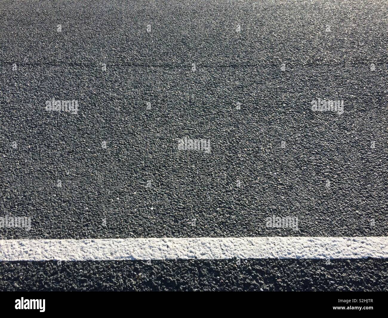 Close-up Detail der asphaltierten Straße mit weißer Markierung Stockfoto