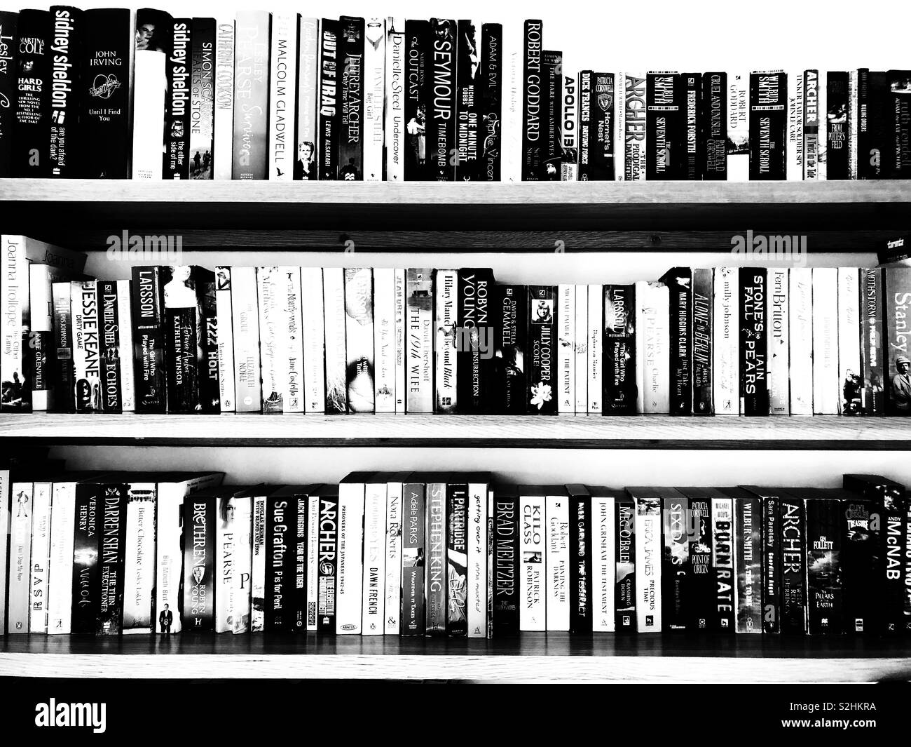 Bücherregal voller Taschenbücher in Schwarz und Weiß Stockfoto