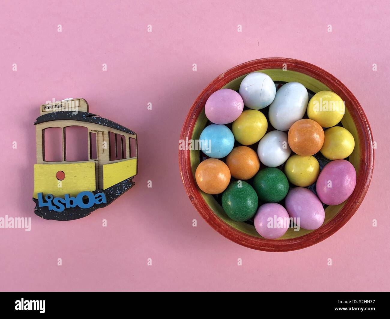 Souvenir von Lissabon mit bunten Pralinen in einer Keramik Schüssel und einem handgefertigten Holz- Straßenbahn Miniatur Stockfoto