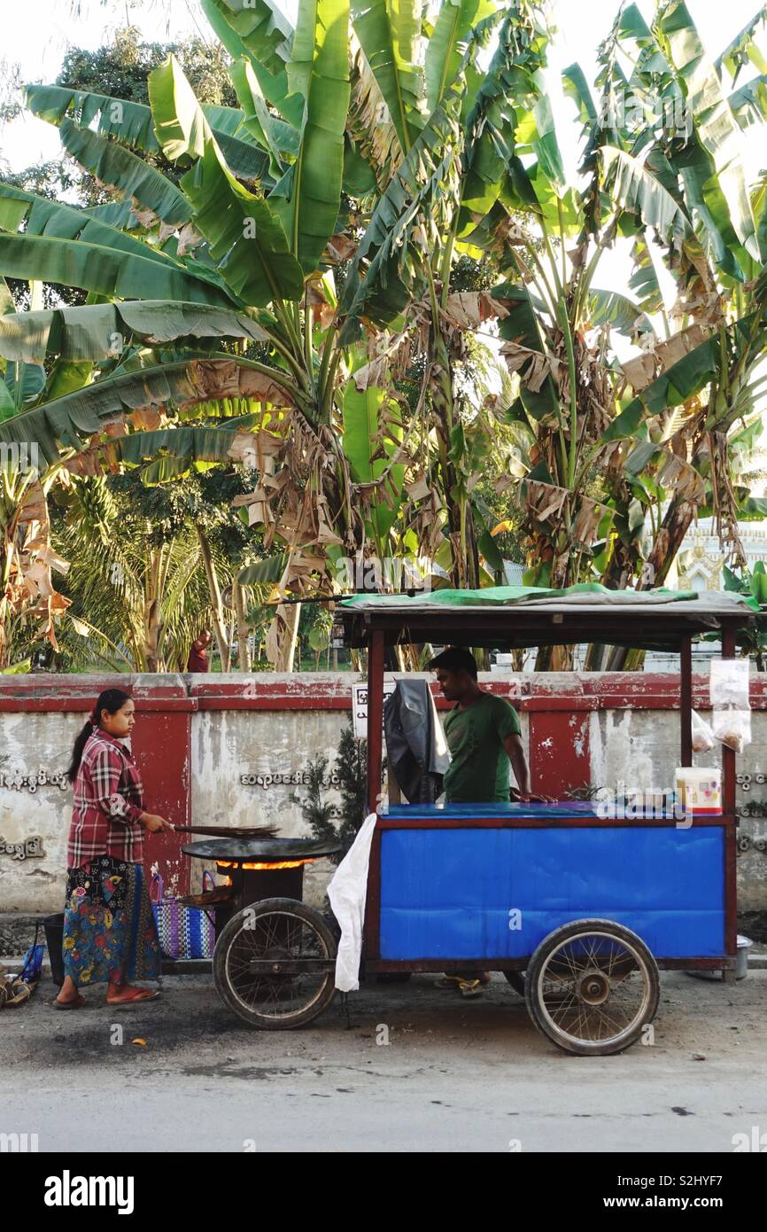 Impressionen der Burmesischen alltäglichen Leben auf der Straße: kleine Anbieter in einer Seitenstraße unter ein Dach von Palm Blätter Stockfoto