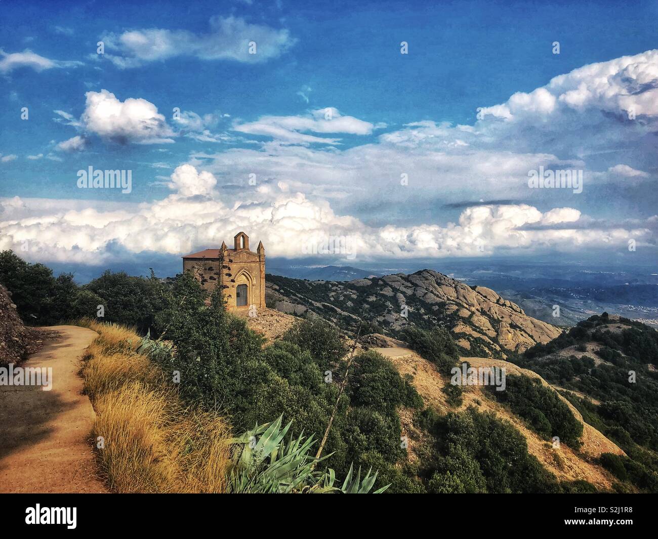 Eine kleine Kapelle, die oben auf den Klippen der Berg Montserrat im Hintergrund der Wolken Spanien. Stockfoto