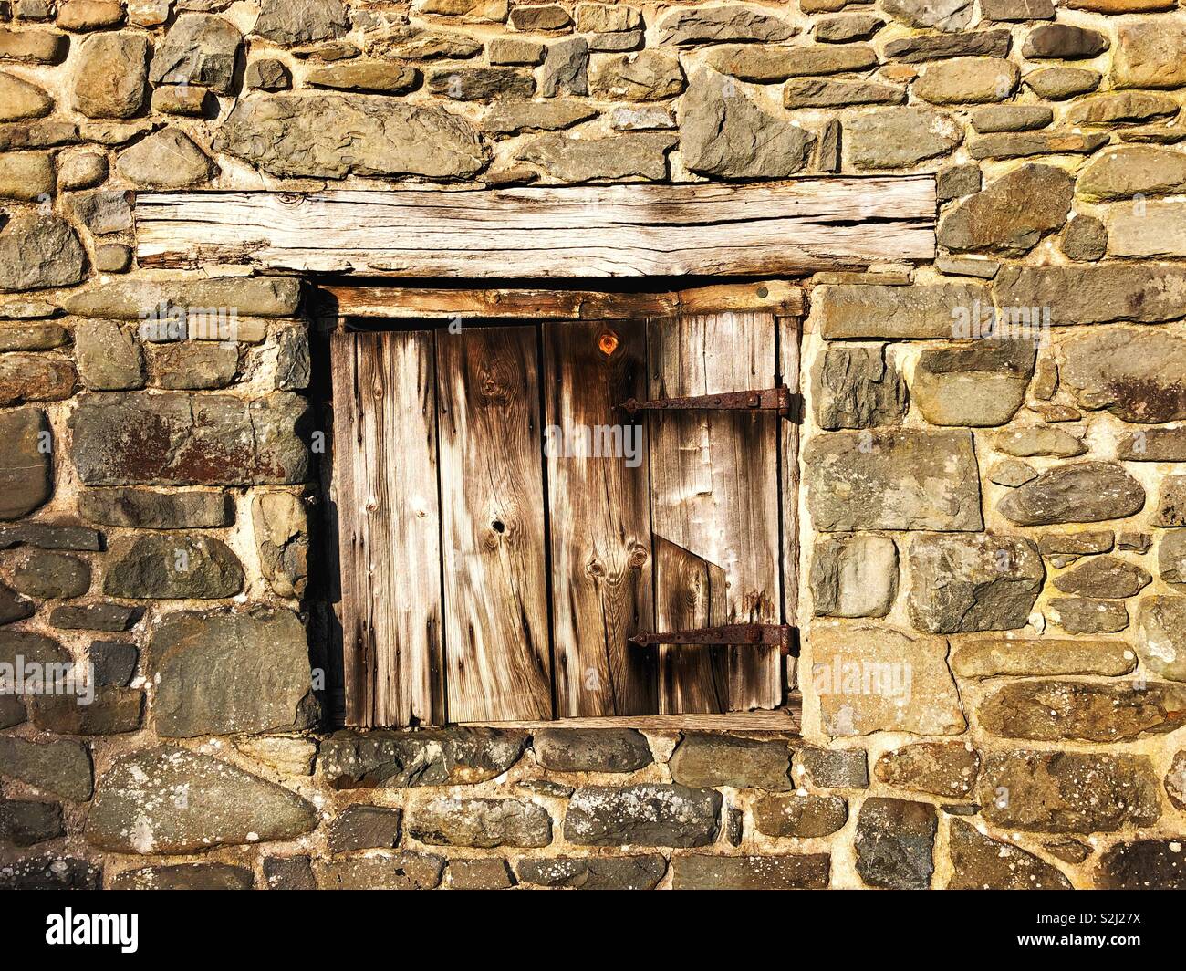 Holz- Verschluss in einer alten Steinmauer Stockfoto