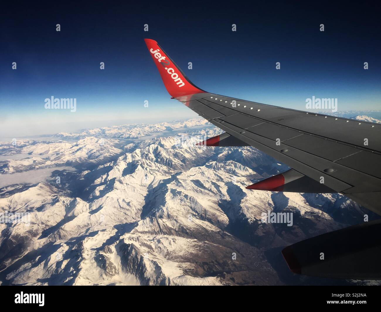 Die Flügel einer Jet2.com Flugzeug über verschneite Berge Stockfoto