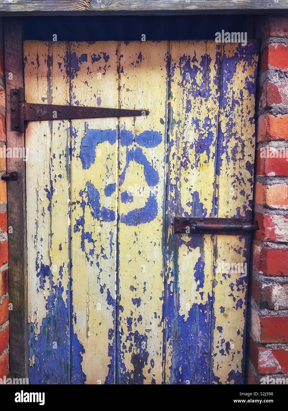 Alte abblätternde Farbe auf einem außerhalb der WC-Tür. Stockfoto